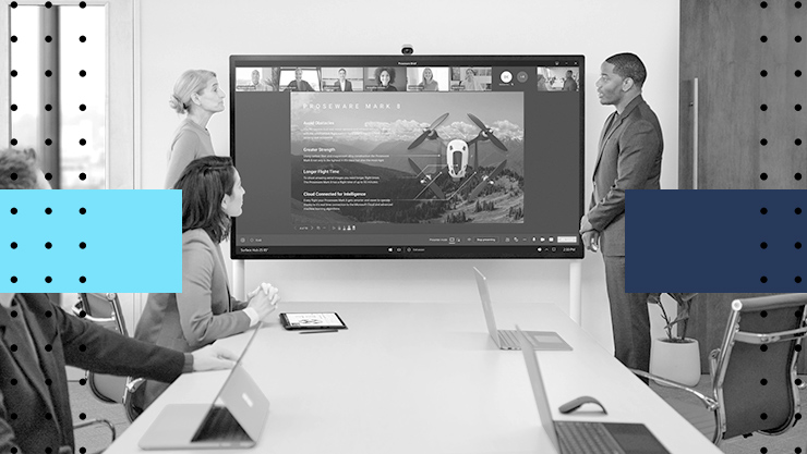 People collaborating in front of a large monitor in a meeting room
