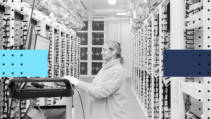 A woman working on a computer in a server lab