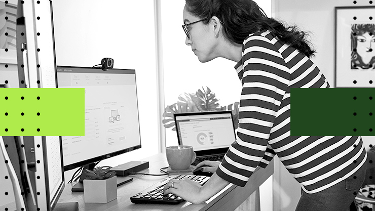 A woman at her desk looking at her computer monitor