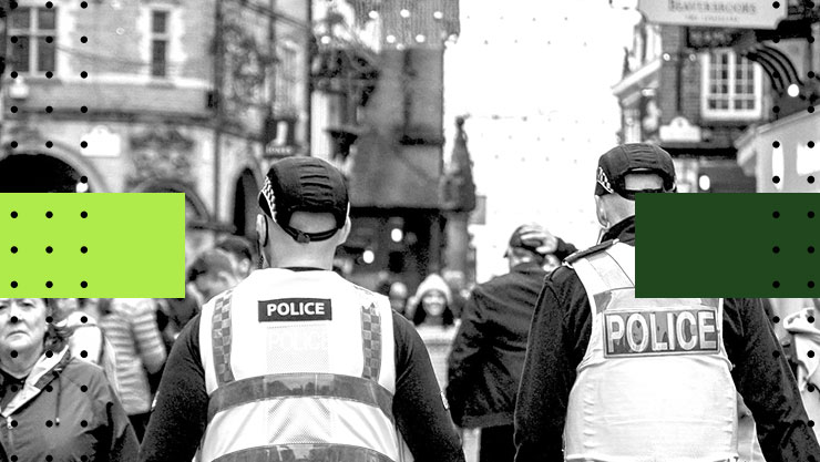Two police officers walking on a crowded street in Cheshire, England