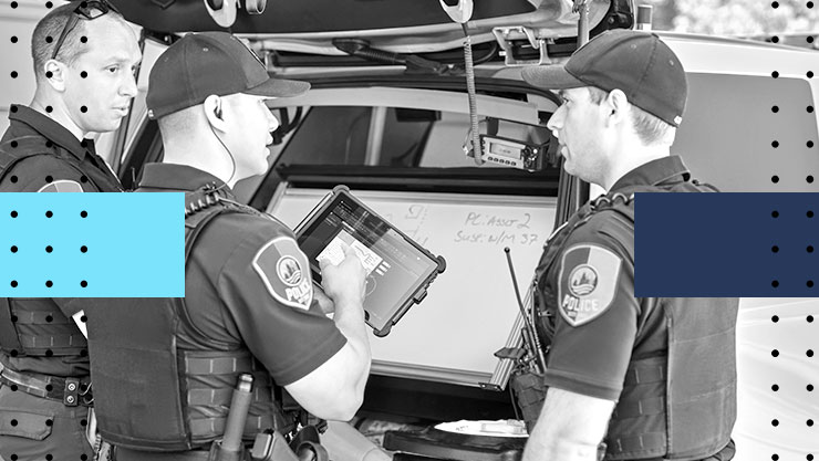 Three police officers collaborating in front of a tablet