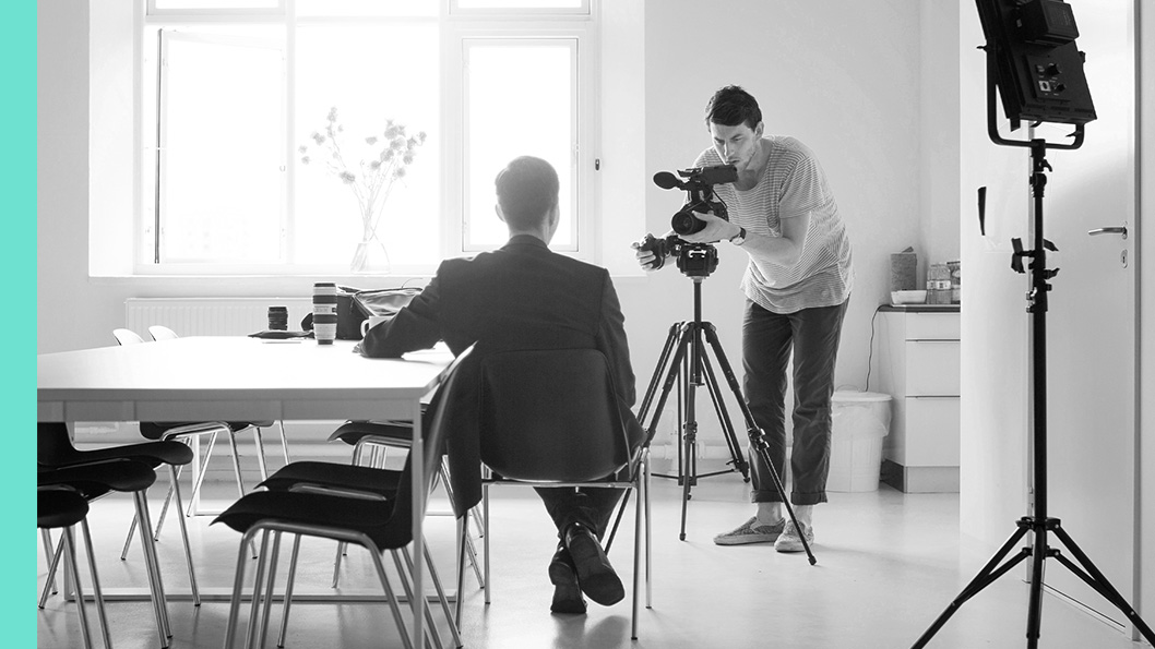 A man sitting in an office in front of a camera