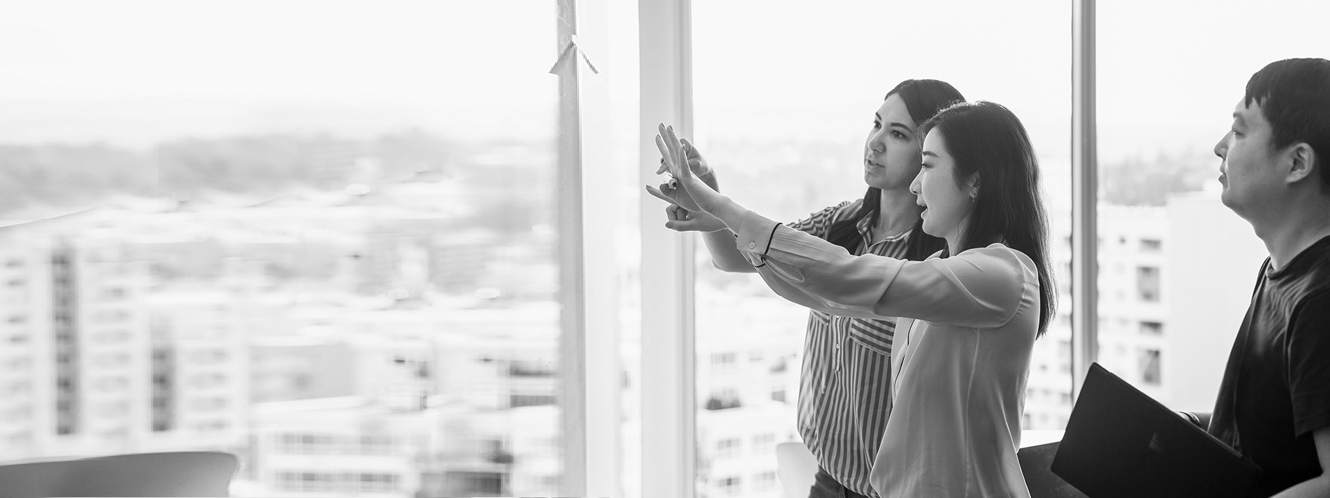 Three colleagues strategize and collaborate in a conference room.