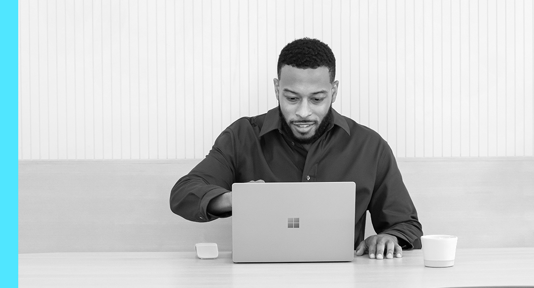 A man sitting at a desk looking at his laptop screen
