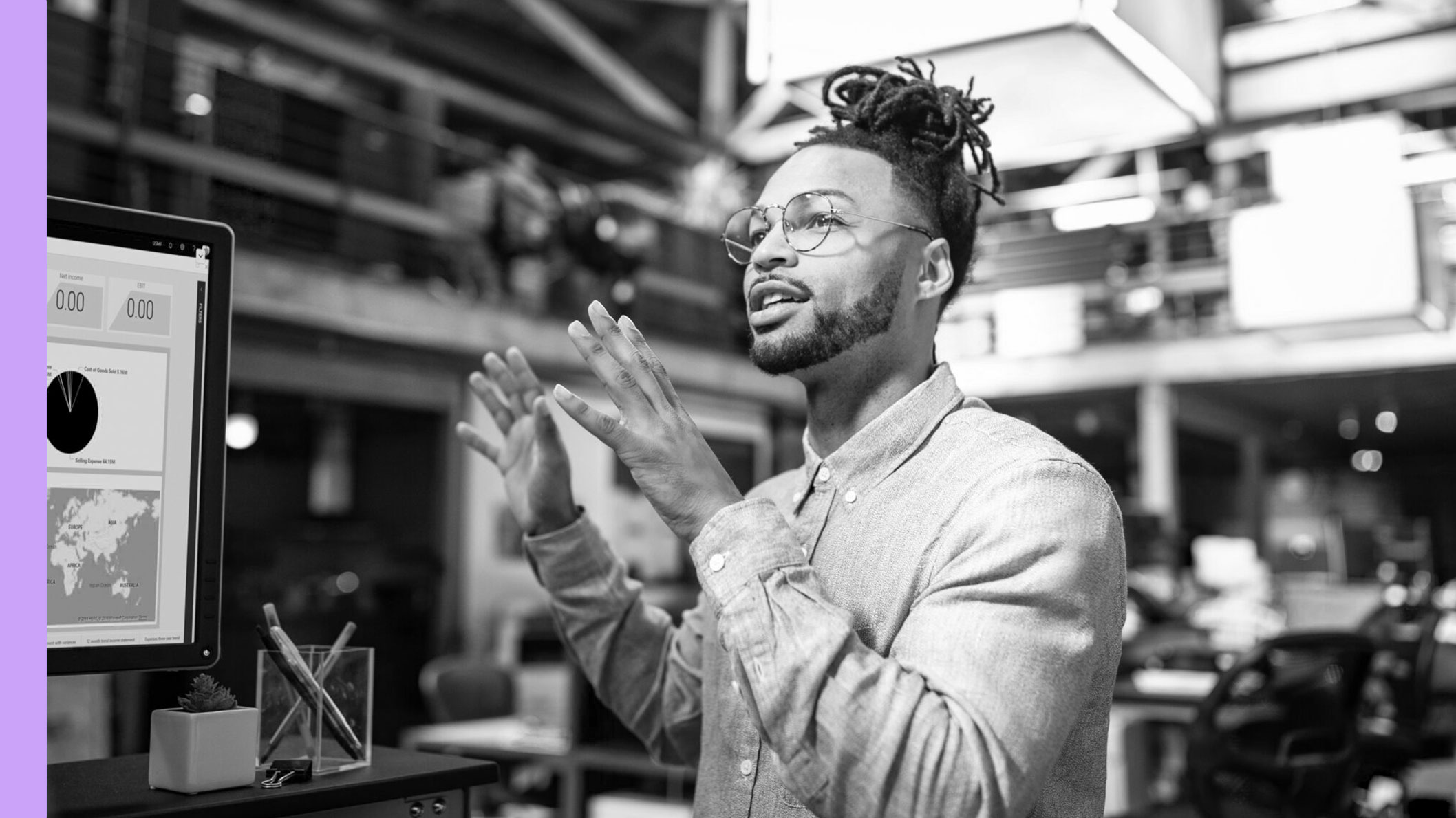 A man explaining something in front of a computer monitor