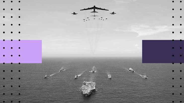 A fleet of military ships arranged in formation on the ocean surface with aircraft flying above the ships in precise alignment.