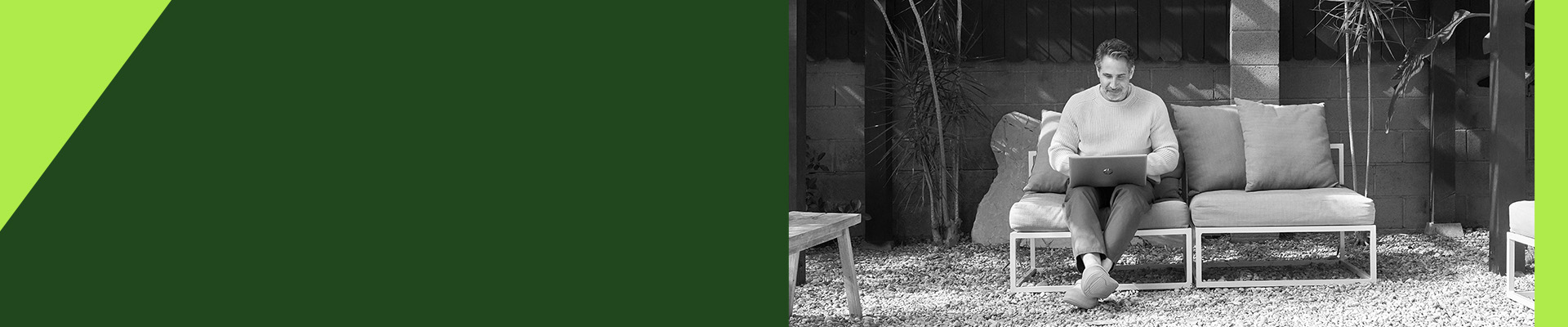 A man sitting in his yard using his laptop