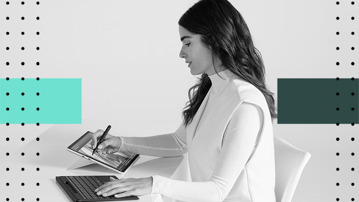 A woman working on a tablet at her desk