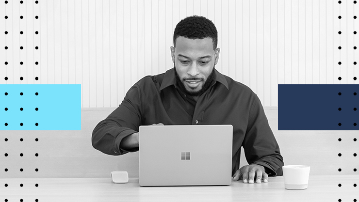 A man sitting at a desk looking at his laptop screen