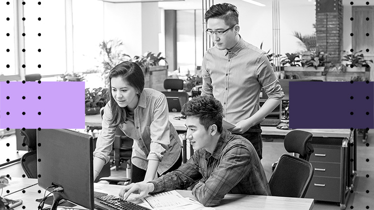 A group of people looking at a computer monitor