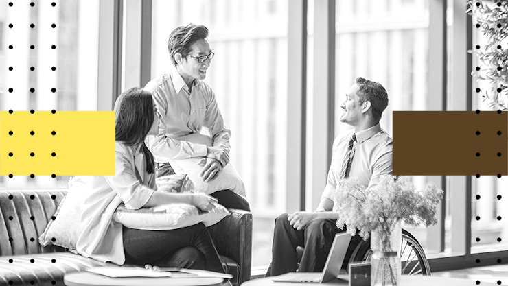 Three people having a discussion in an office