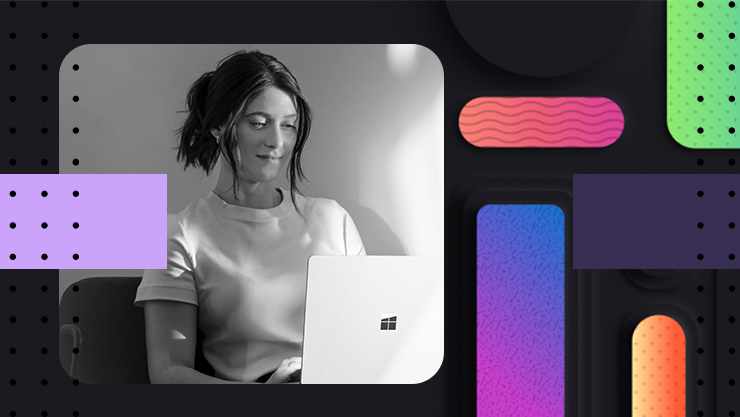 Woman with a smile on her face, looking down at her laptop