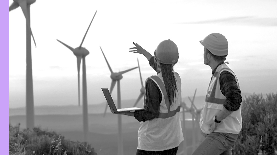 Two windfarm workers looking out over the windfarm