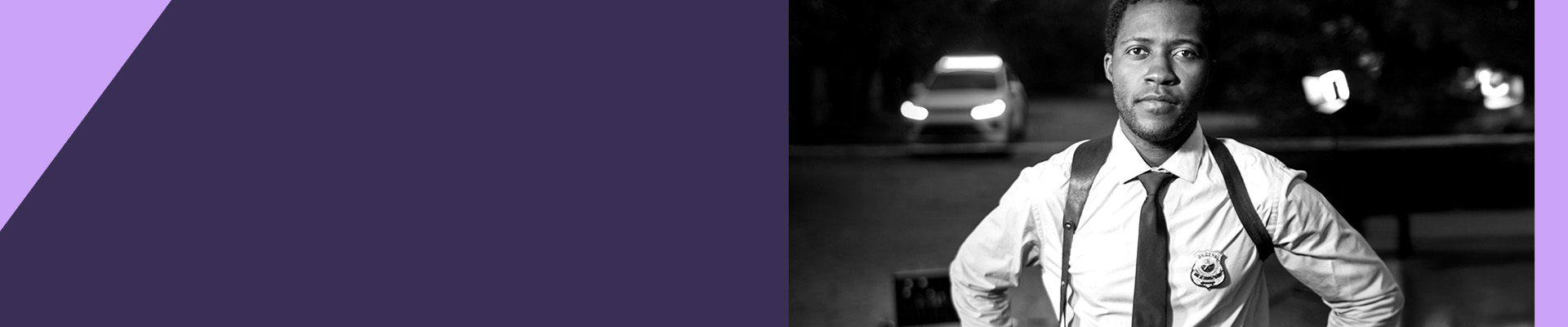 A police officer standing near a roadway with a car in the background.