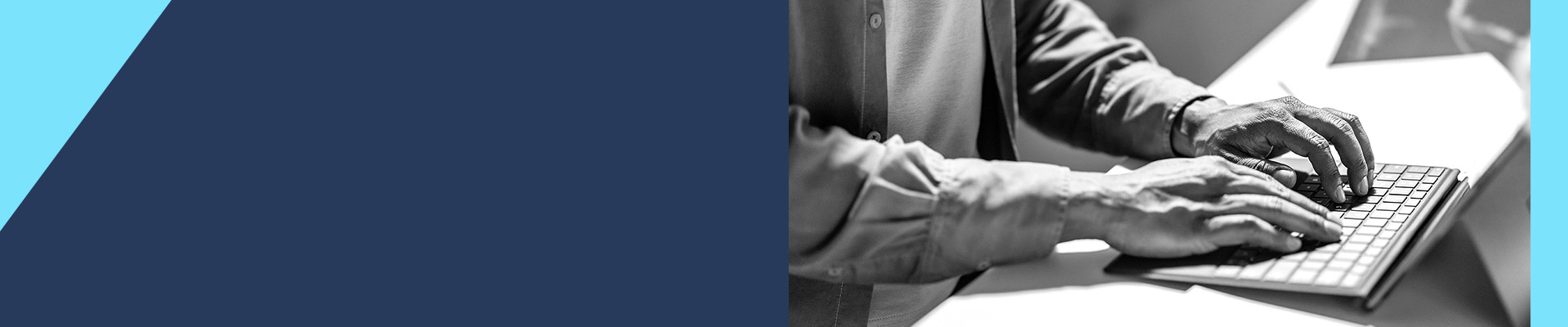 Close-up of hands typing on a laptop keyboard.
